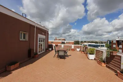 a patio with a table and chairs on a balcony at Pironti Flat in Rome