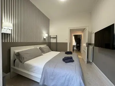 a bedroom with a large white bed and a flat screen tv at rome via veneto in Rome