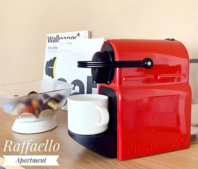a red toaster sitting on a table with a bowl of food at Raffaello Apartment in Rome