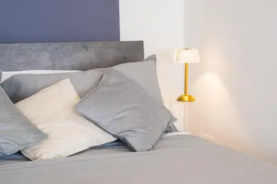 a bed with pillows and a lamp on it at Attico Esclusivo Trastevere with Rooftop Terrace in Rome