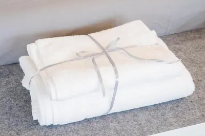 a white towel with a bow on the floor at Attico Esclusivo Trastevere with Rooftop Terrace in Rome