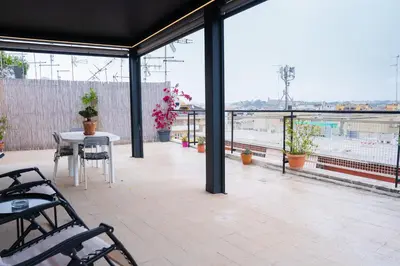 a patio with a table and chairs and a view of a city at Attico Esclusivo Trastevere with Rooftop Terrace in Rome