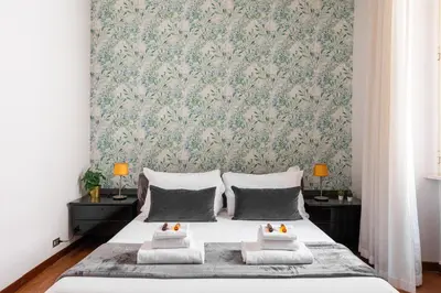 a bedroom with a bed with a floral wallpaper at Appartamento via Quintino Sella in Rome
