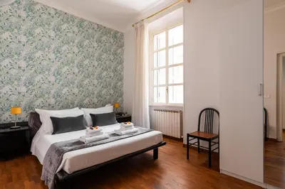a bedroom with a bed with a floral wallpaper at Appartamento via Quintino Sella in Rome