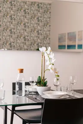 a table with glasses and a vase with a flower on it at Appartamento via Quintino Sella in Rome