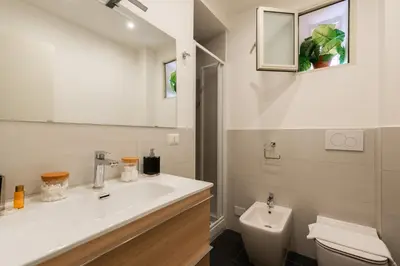 a white bathroom with a sink and a toilet at Appartamento via Quintino Sella in Rome