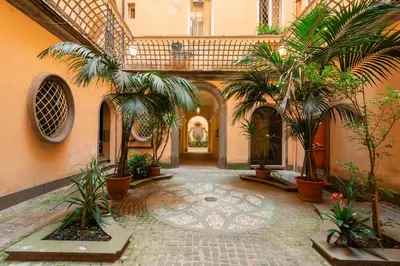 a courtyard with palm trees in a building at Appartamento via Quintino Sella in Rome