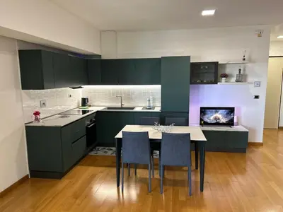 a kitchen with green cabinets and a table and chairs at Del Vecchio Apartment in Rome