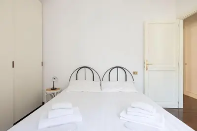 a white bedroom with a white bed with white pillows at St Peter House by Varental in Rome