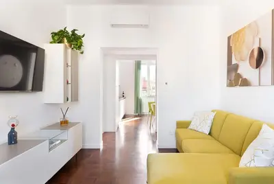 a living room with a yellow couch and a table at Idyllia - Bright and modern apt in Rome