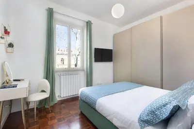 a bedroom with a bed and a desk and a window at Idyllia - Bright and modern apt in Rome
