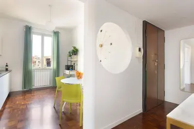 a kitchen with a table and a clock on the wall at Idyllia - Bright and modern apt in Rome