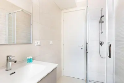 a white bathroom with a sink and a shower at Idyllia - Bright and modern apt in Rome