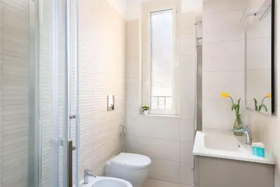 a white bathroom with a toilet and a sink at Idyllia - Bright and modern apt in Rome