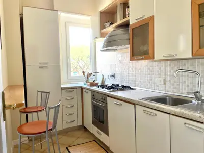 a kitchen with white cabinets and a sink and a window at Onesti House - San Paolo in Rome