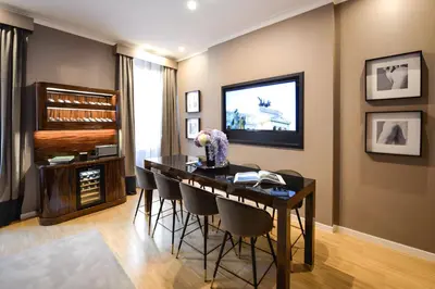 a dining room with a table and chairs and a television at The Condotti - Luxury serviced apartment in Rome