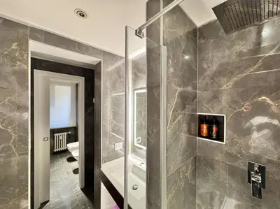a bathroom with a walk in shower and a toilet at The Condotti - Luxury serviced apartment in Rome