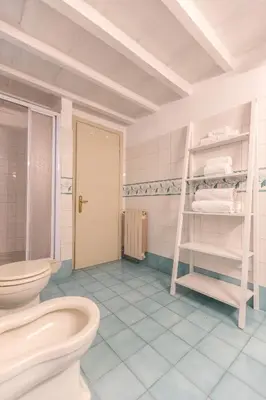 a bathroom with a toilet and a shelf with towels at Piazza Navona Classy & Large Apartment in Rome