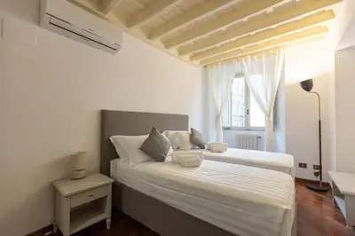a bedroom with a bed with white sheets and a window at Piazza Navona Classy & Large Apartment in Rome