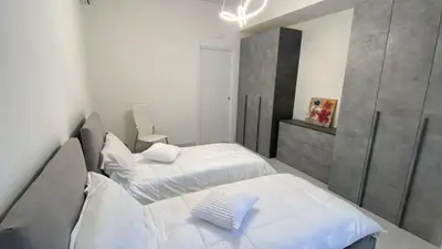 two beds in a small room with white walls at Tiburtina Flats in Rome