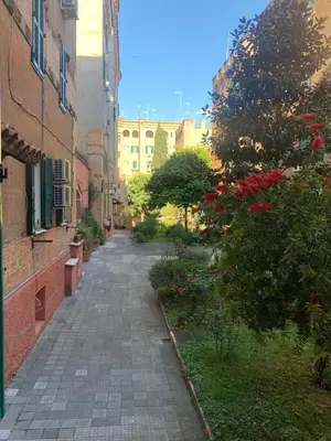 an empty alley in a city with buildings and flowers at Appartamento degli Eroi in Rome