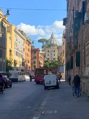a city street with buildings and a car and people on bikes at Appartamento degli Eroi in Rome