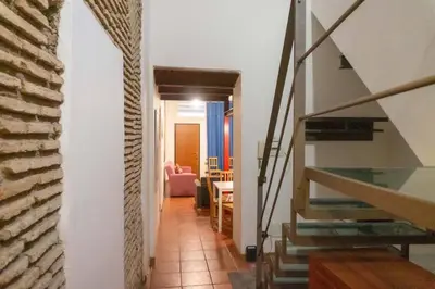 a hallway with a staircase and a living room at Domus Reginella, nella zona più richiesta di Roma in Rome