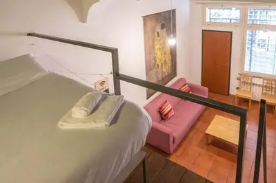 a bedroom with a bed and a pink couch at Domus Reginella, nella zona più richiesta di Roma in Rome