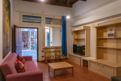 a living room with a pink couch and a table at Domus Reginella, nella zona più richiesta di Roma in Rome