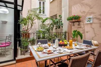 a table with food on it on a patio at Sant'Andrea - Opulence Apartment in Rome