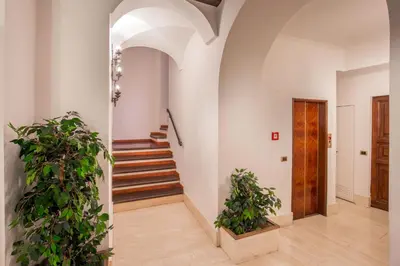 a hallway with stairs and potted plants at Sant'Andrea - Opulence Apartment in Rome