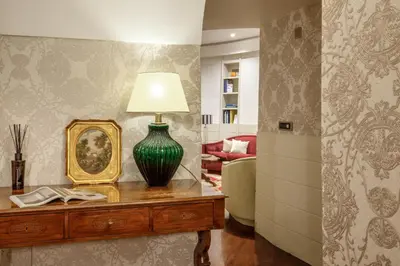a living room with a table with a lamp on it at Sant'Andrea - Opulence Apartment in Rome