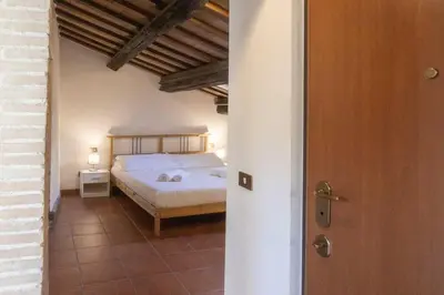 a bedroom with a bed and a table with a lamp at Domus Tempio Deluxe, Roma Centro in Rome