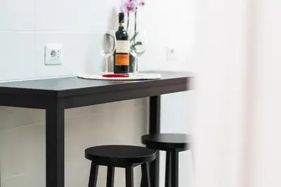 a table with two stools and a bottle of wine at Domus Leo Roma in Rome