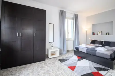 a bedroom with a bed with black cabinets and a rug at Opera 65 Roof Terrace in Rome