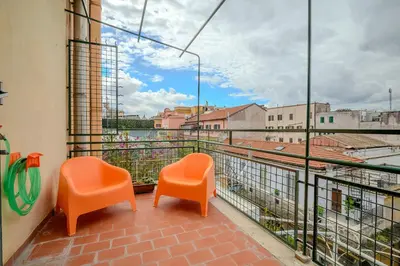 two orange chairs sitting on a balcony with a view at Opera 65 Roof Terrace in Rome