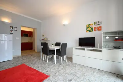 a living room with a table with chairs and a television at Opera 65 Roof Terrace in Rome