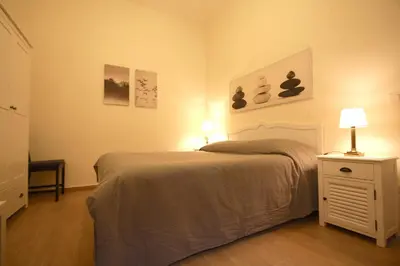 a bedroom with a bed and a nightstand with two lamps at San Lorenzo Holiday House in Rome