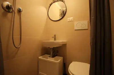 a bathroom with a toilet and a sink and a mirror at San Lorenzo Holiday House in Rome