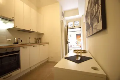 a kitchen with white cabinets and a counter with a candle on it at San Lorenzo Holiday House in Rome
