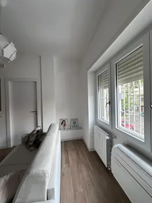 a white living room with a couch and a window at Otium - Tarquinia in Rome