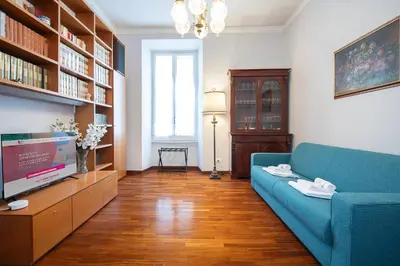 a living room with a blue couch and a tv at Jubilee apartment Vatican Museums in Rome
