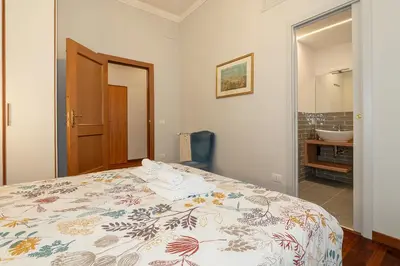 a bedroom with a bed and a bathroom with a sink at Jubilee apartment Vatican Museums in Rome