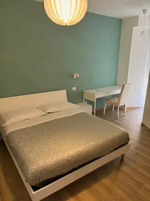 a bedroom with a bed and a table and a chandelier at Suite and room in Rome