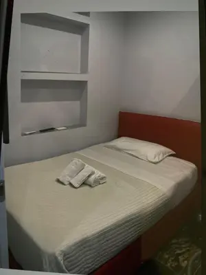 a small bed with two towels on top of it at Suite and room in Rome