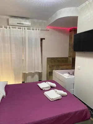 a bedroom with a purple bed with towels on it at Suite and room in Rome