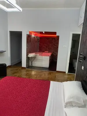 a bedroom with a bed and a red rug at Suite and room in Rome