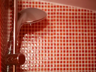 a shower head in front of a red tiled wall at Sweet Home Colosseo in Rome