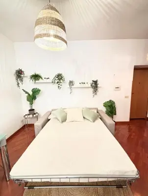 a large bed in a room with a couch at Saulo Guest House - A 10 minuti da Colosseo in Rome