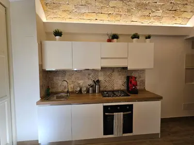 a kitchen with white cabinets and a sink at Campani Luxury Suite in Rome